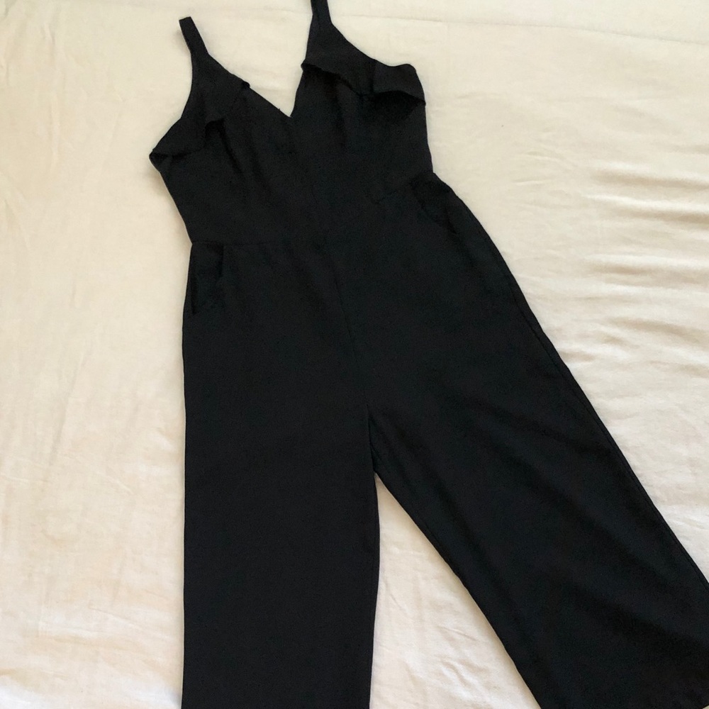 Black jumpsuit with ruffle detail and pockets